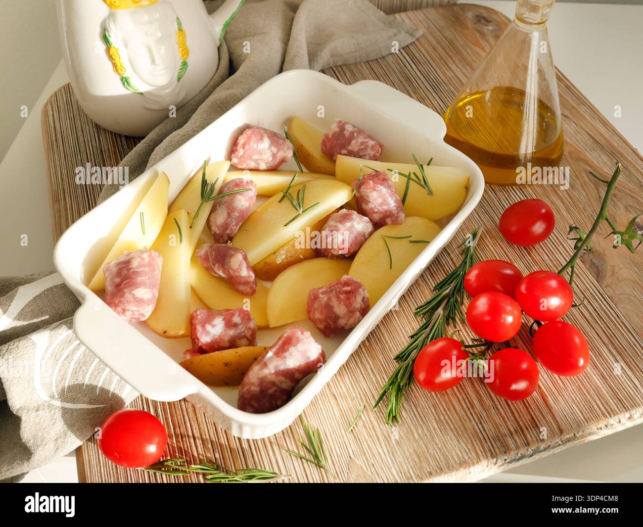 Kartoffelscheiben und hausgemachte Würstchen aus Fleisch aus Bauernhof, zubereitet zum Backen in Keramikform. Ernährung und Gesundheit. Gewürze und Naturprodukte. Stockfoto