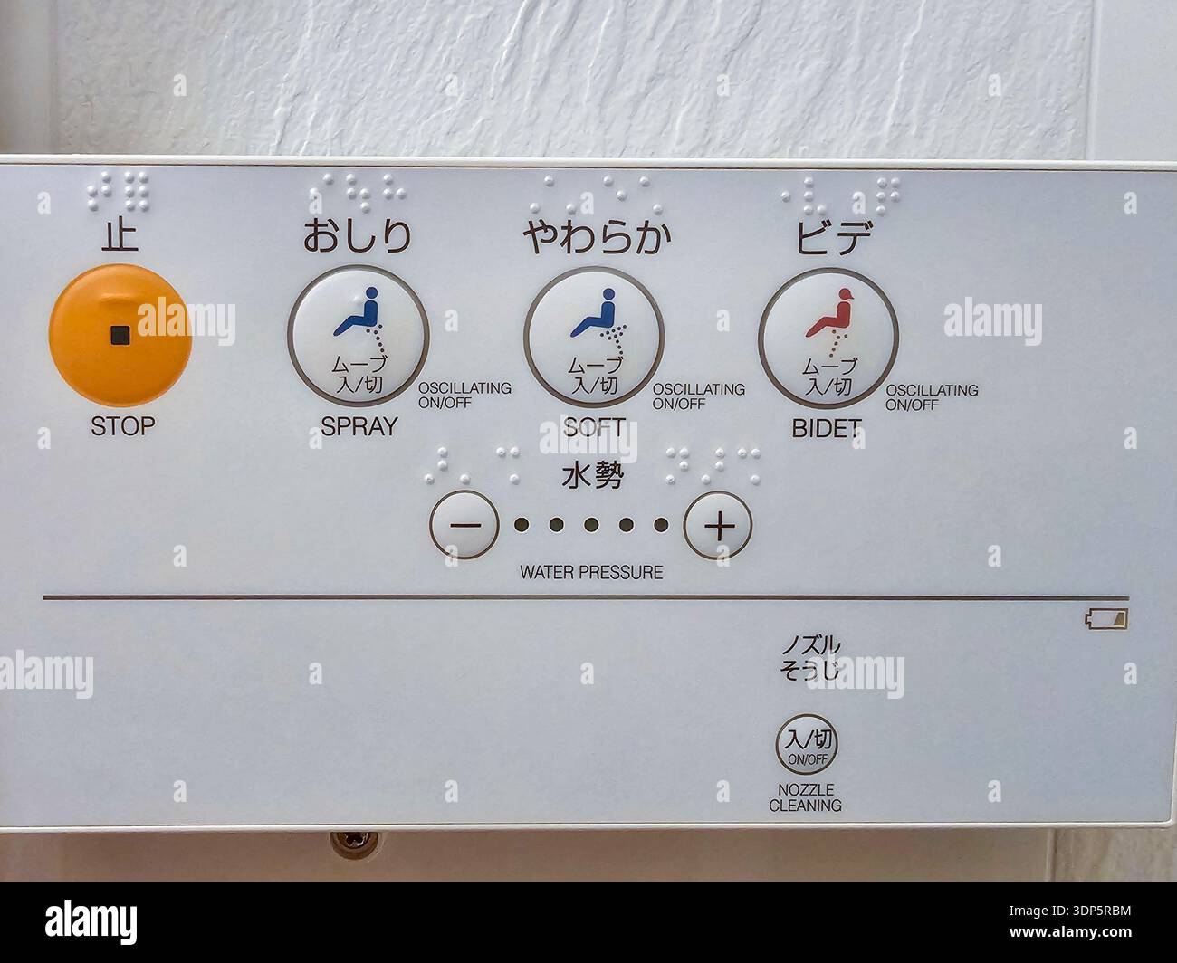 Nahaufnahme eines japanischen Bidet-Bedienfelds mit Braille-Schrift, mit Tasten für Sprach-, Soft-Wash-, Stopp- und Wasserdruckeinstellungen. Stockfoto