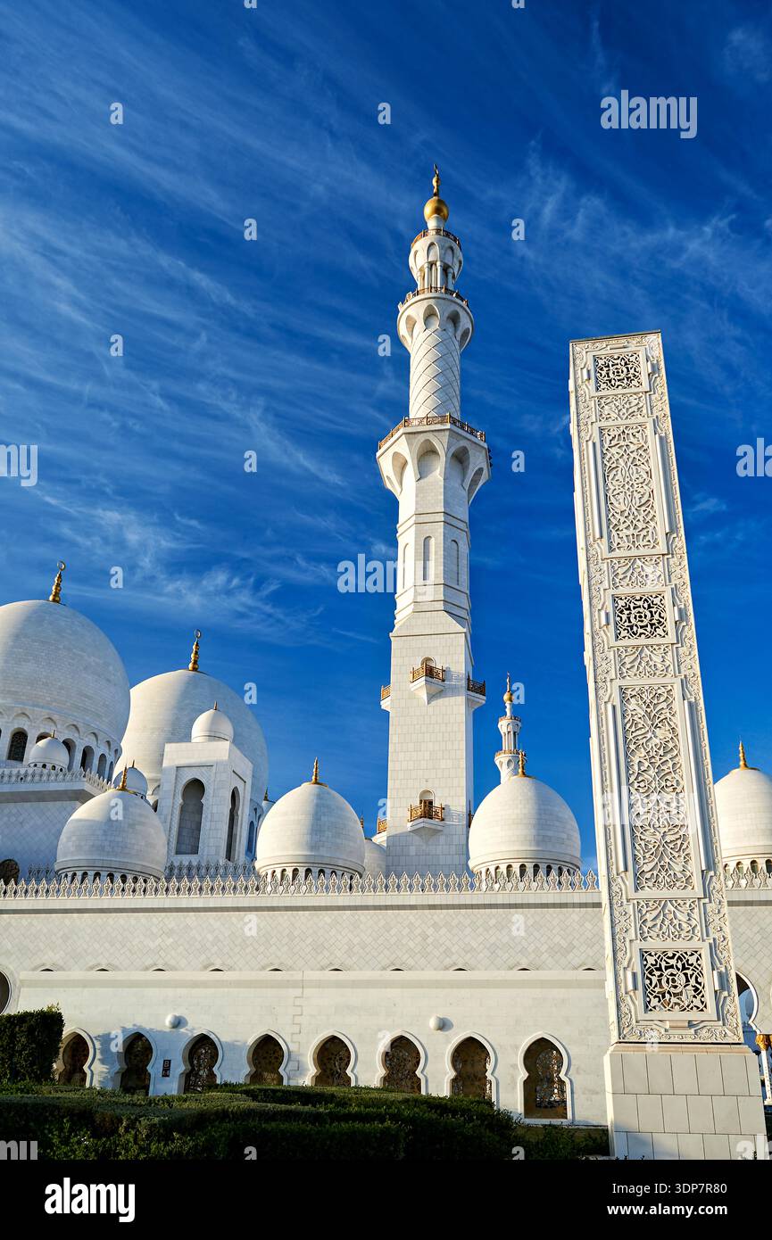 Die weißen Marmorkuppeln und das Minarett der Scheich-Zayed-Moschee in Abu Dhabi, VAE, heben sich von einem strahlend blauen Himmel ab. Stockfoto