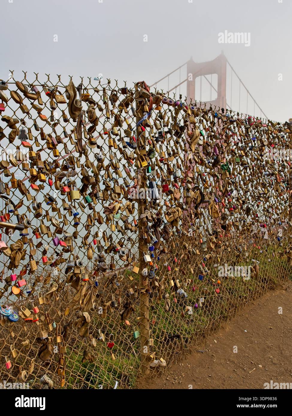 Love Loves am Maschendrahtzaun am Battery Spencer Overlook mit nebligem Golden Gate Bridge Tower Stockfoto