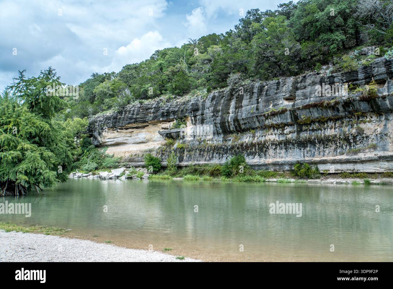 Ein Fluss fließt durch einen felsigen Canyon. Das Wasser ist klar und ruhig. Die Umgebung ist üppig und grün Stockfoto
