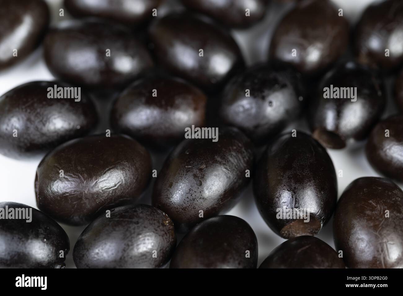 Reife schwarze Oliven glitzern als Snack, intimer Makrorahmen, appetitlicher Glanz, perfekt für Antipasto, Tapas, Partyessen und gesunde Lebensweise visuell Stockfoto