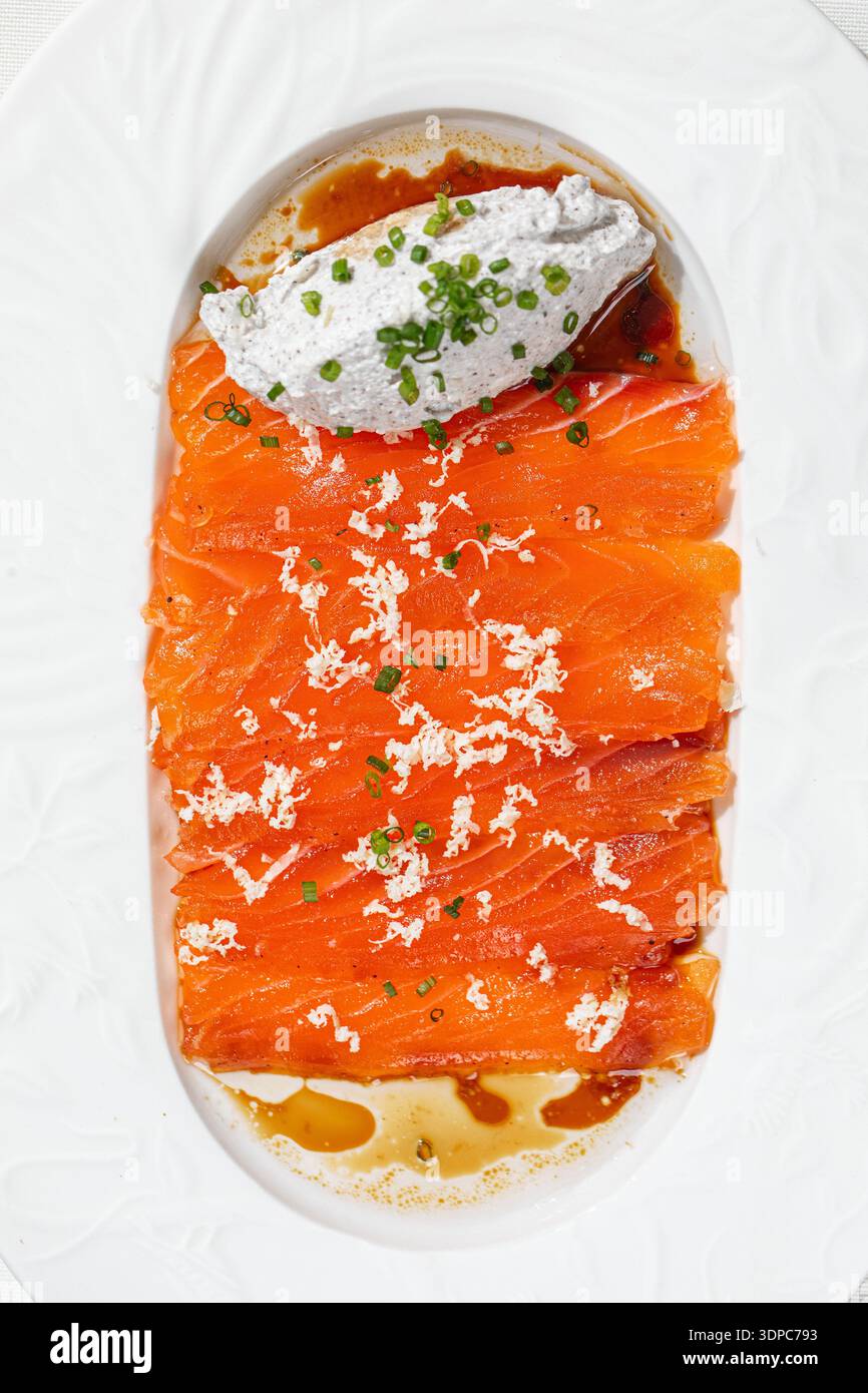 Lachsscheiben mit cremiger Sauce und Kräutern Stockfoto