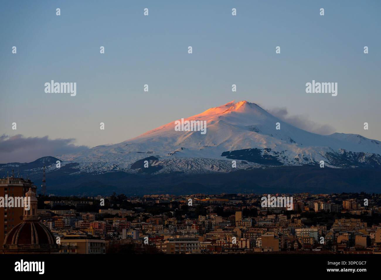 Der verschneite Ätna wird von Sonnenuntergang beleuchtet, von Catania in Sizilien aus gesehen Stockfoto