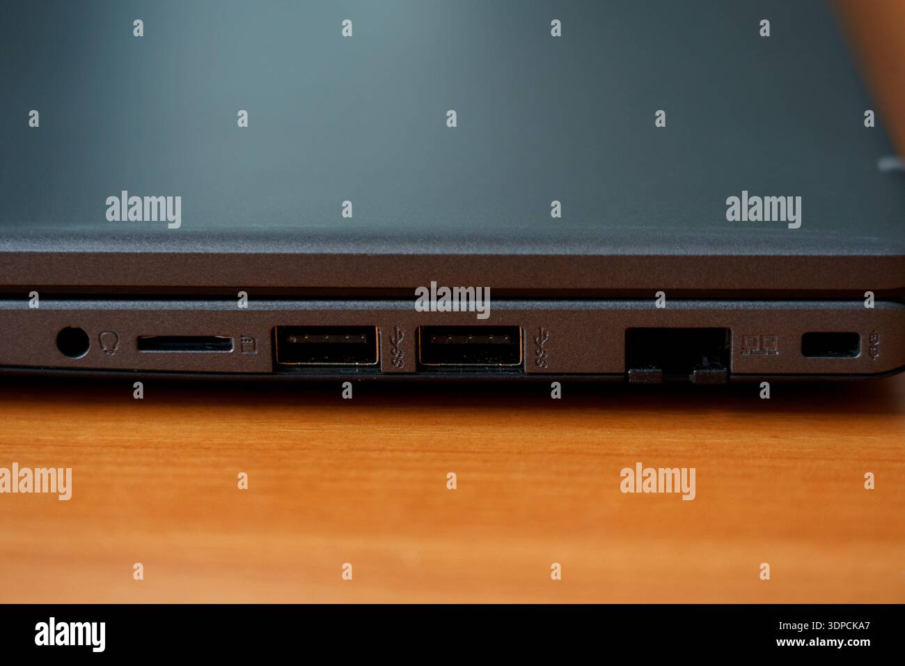 Eine Nahaufnahme der Seite eines Laptops zeigt verschiedene Anschlüsse, einschließlich USB, HDMI und Kartenleser. Diese Konfiguration ist nützlich, um verschiedene Geräte anzuschließen. Stockfoto