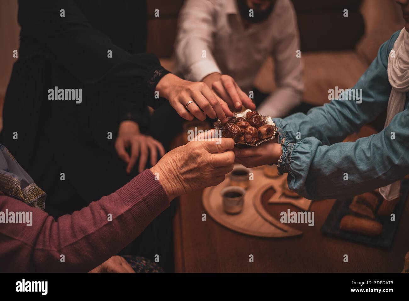 Daten während der Ramadan-Feier aus nächster Nähe: Mitglieder der muslimischen Generation, die während des Iftar traditionelle Speisen genießen Stockfoto