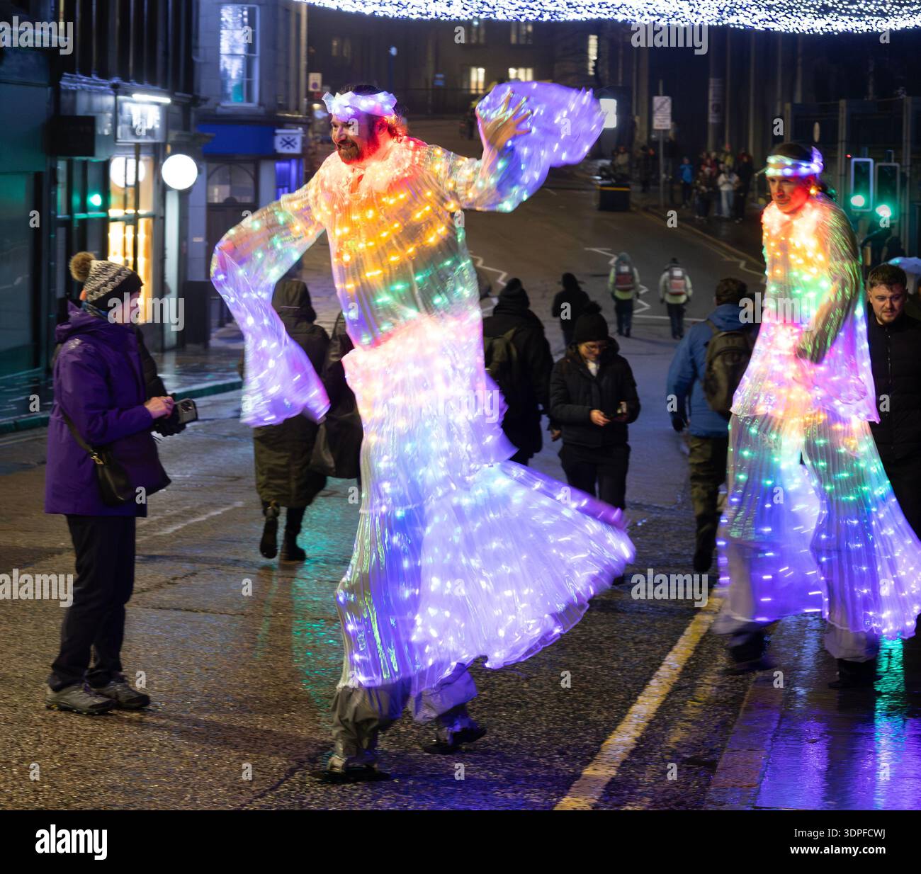 Straßenkünstler auf Stelzen in beleuchteten Kostümen während des Spectra Festival of Light 2026 im Stadtzentrum von Aberdeen. Schottland. Stockfoto