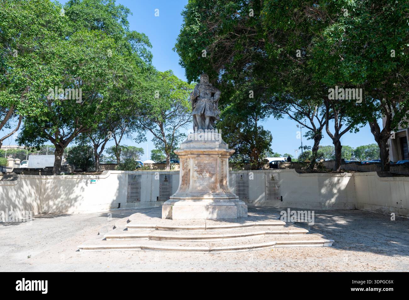 Denkmal Statue des Großmeisters Antonio Manoel de Vilhena auf einem Steinsockel, eingerahmt von Bäumen und hellem Sommersonnenlicht in Valletta, Malta. Stockfoto
