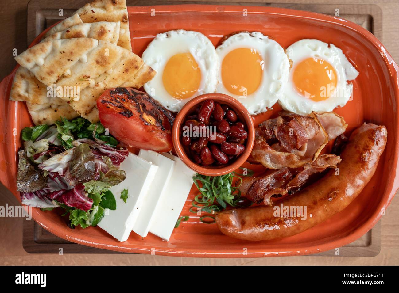 Herzhafte Frühstücksplatte mit Eiern, Würstchen und frischem Gemüse Stockfoto