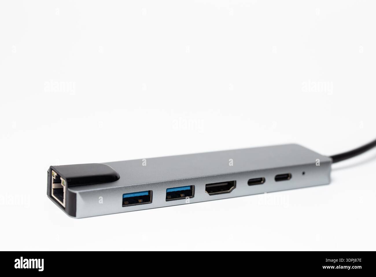 Nahaufnahme des silbernen USB-C-Hubs mit RJ45 HDMI- und USB-A-Anschlüssen auf weißem Hintergrund. Stockfoto