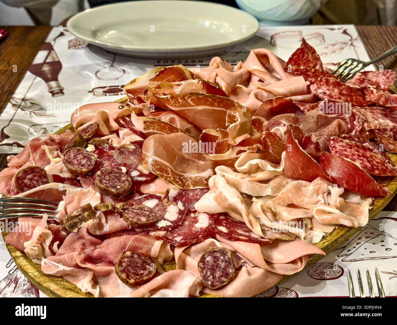 Traditionelle italienische Tagliere: Authentische Antipasti-Platte mit Wurstwaren, handwerklichem Käse und frischen mediterranen Früchten auf einem rustikalen Holzbrett Stockfoto