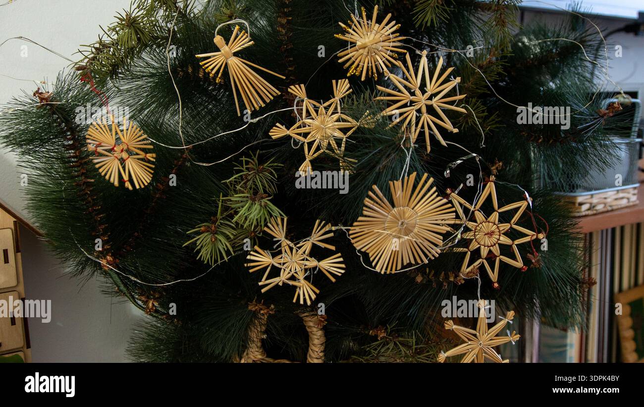 Strohweihnachtsschmuck am Baum. Heim-Winterdekor. Stockfoto