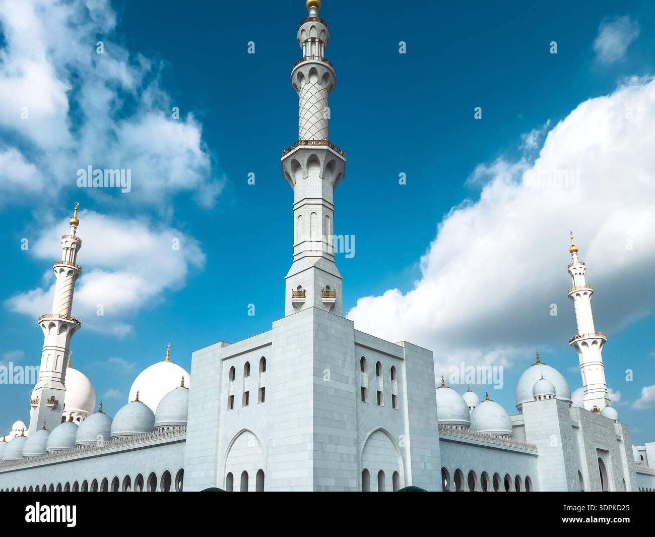 Abu Dhabi, VAE – 4. Januar 2024: Majestätische weiße Kuppeln und Minarette einer großen Moschee stehen unter klarem Himmel und zeigen die Eleganz und Größe des IS Stockfoto