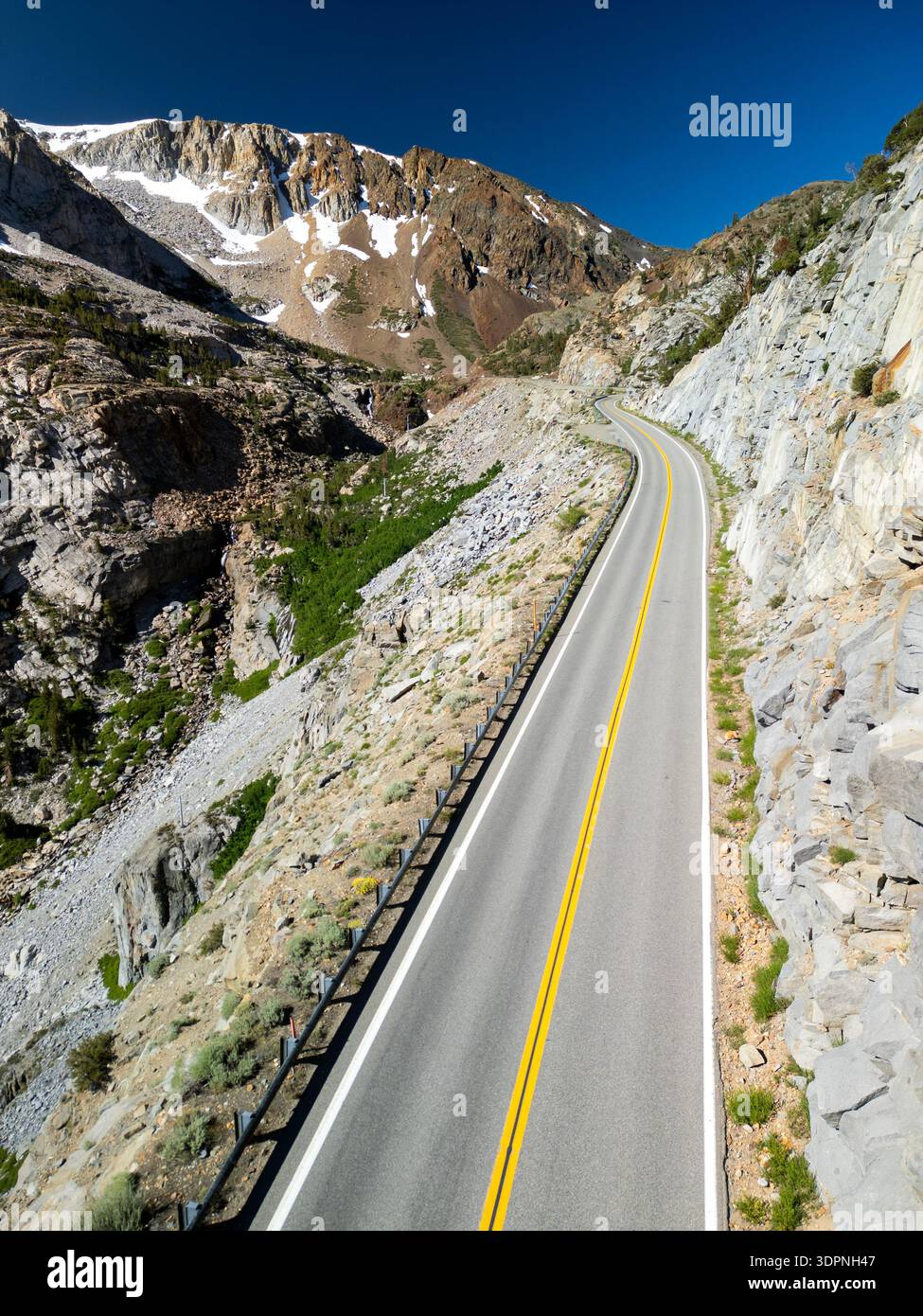 Luftaufnahme einer leeren Autobahn 120 in der dramatischen Landschaft der östlichen Sierras unter blauem Himmel ohne Verkehr Stockfoto