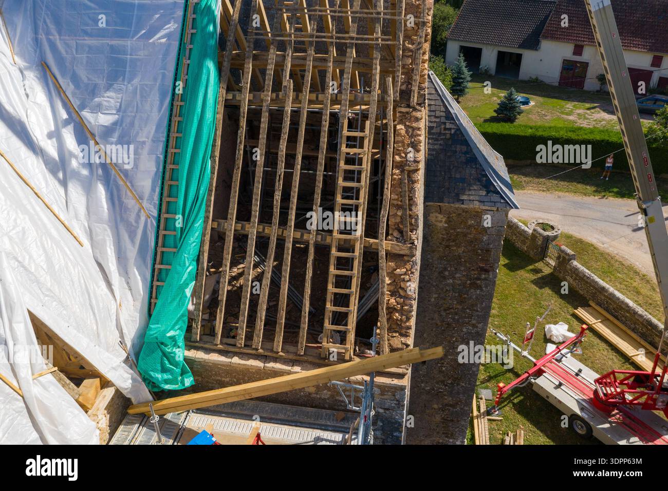 Eglise Saint Martin, Frankreich - 23. Juli 2020: Die Dachkonstruktion der Kirche Eglise Saint Martin ist von oben mit freiliegenden Holzbalken, Gerüsten, Planen und Baugeräten während der Renovierungsarbeiten zu sehen. Stockfoto