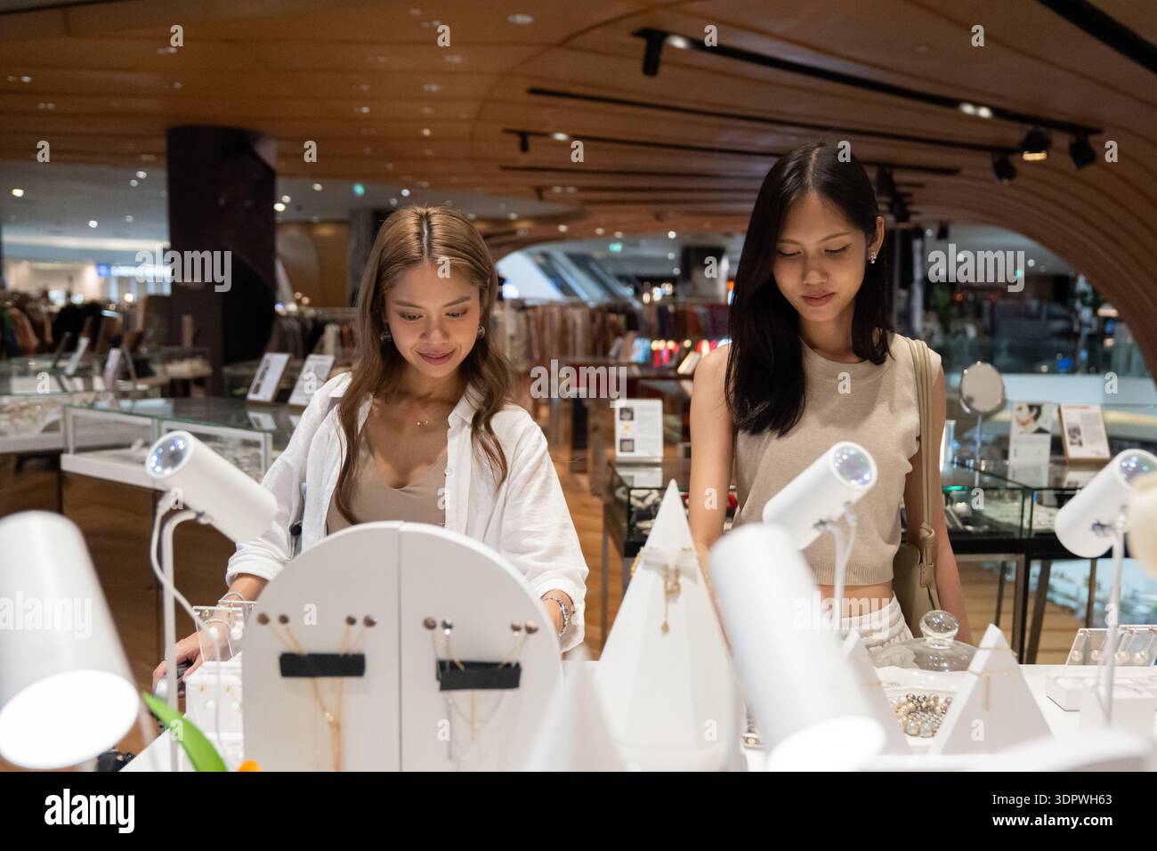 Junge Frauen, die im Kaufhaus feinen Schmuck suchen Stockfoto