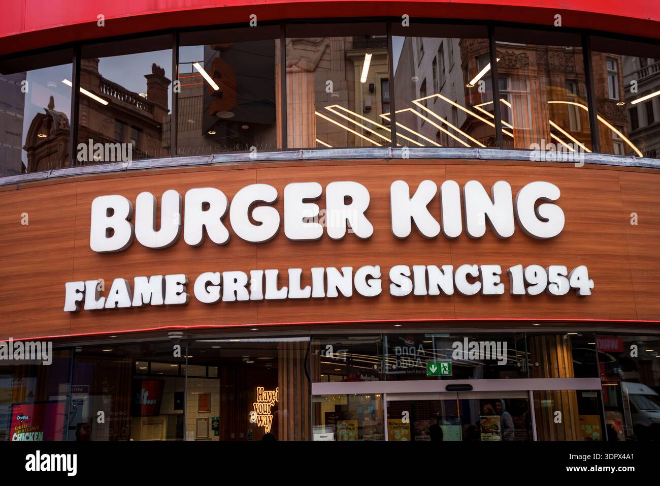 LONDON, GROSSBRITANNIEN. Februar 2025. Äußere eines Burger King Restaurants mit dem Slogan „Flame Grilling since 1954“ auf einer Holzfassade. Stockfoto