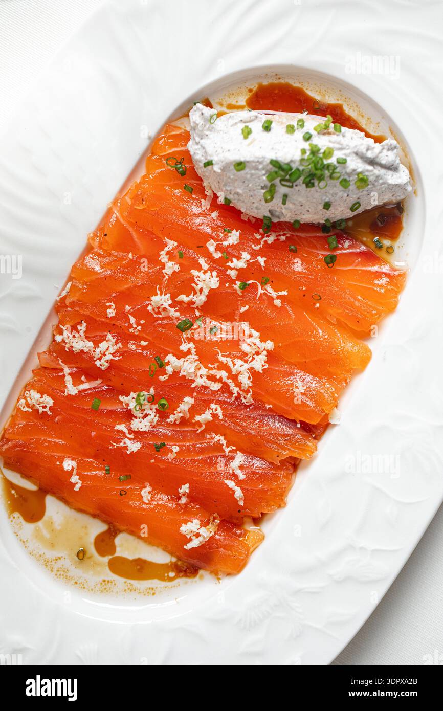 Lachsscheiben mit cremiger Sauce und Kräutern Stockfoto