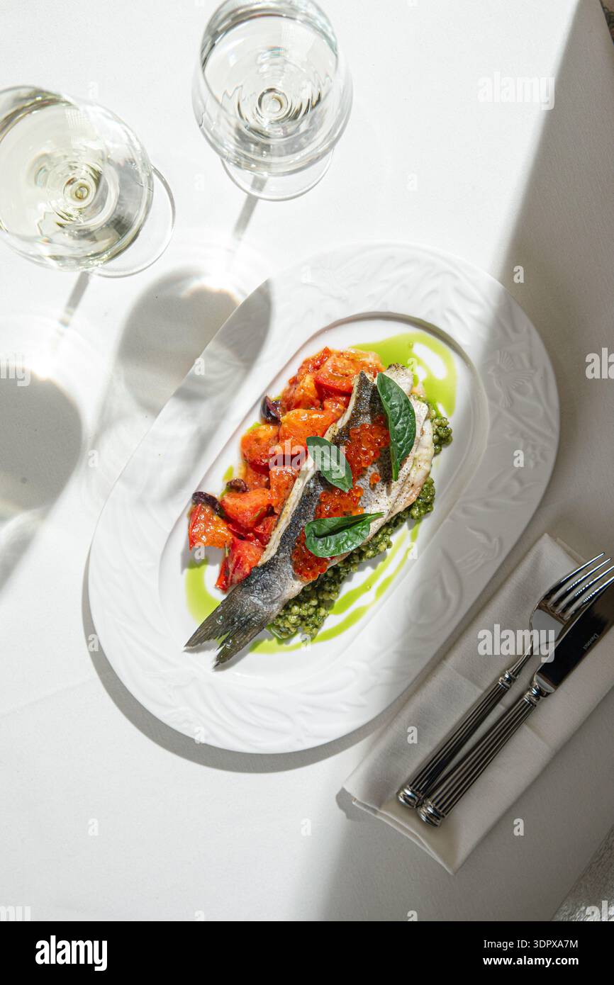 Gebratenes Fischfilet mit Gemüse und grüner Sauce Stockfoto