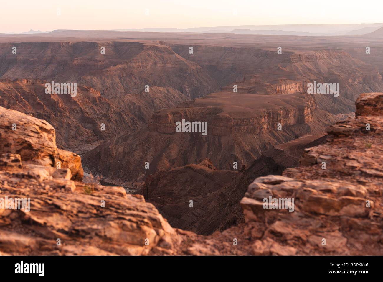 Atemberaubender Blick auf den Fish River Canyon bei Sonnenuntergang, mit seinen zerklüfteten Klippen und der weiten Landschaft, die in warmen, goldenen Tönen getaucht ist Stockfoto