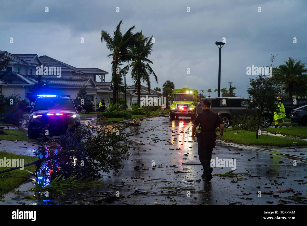 Palm Beach Gardens, USA - 09. Oktober 2024: Blick auf Rettungsfahrzeuge inmitten von Trümmern übersähter Straßen unter einem düsteren Himmel, die das After hervorheben Stockfoto