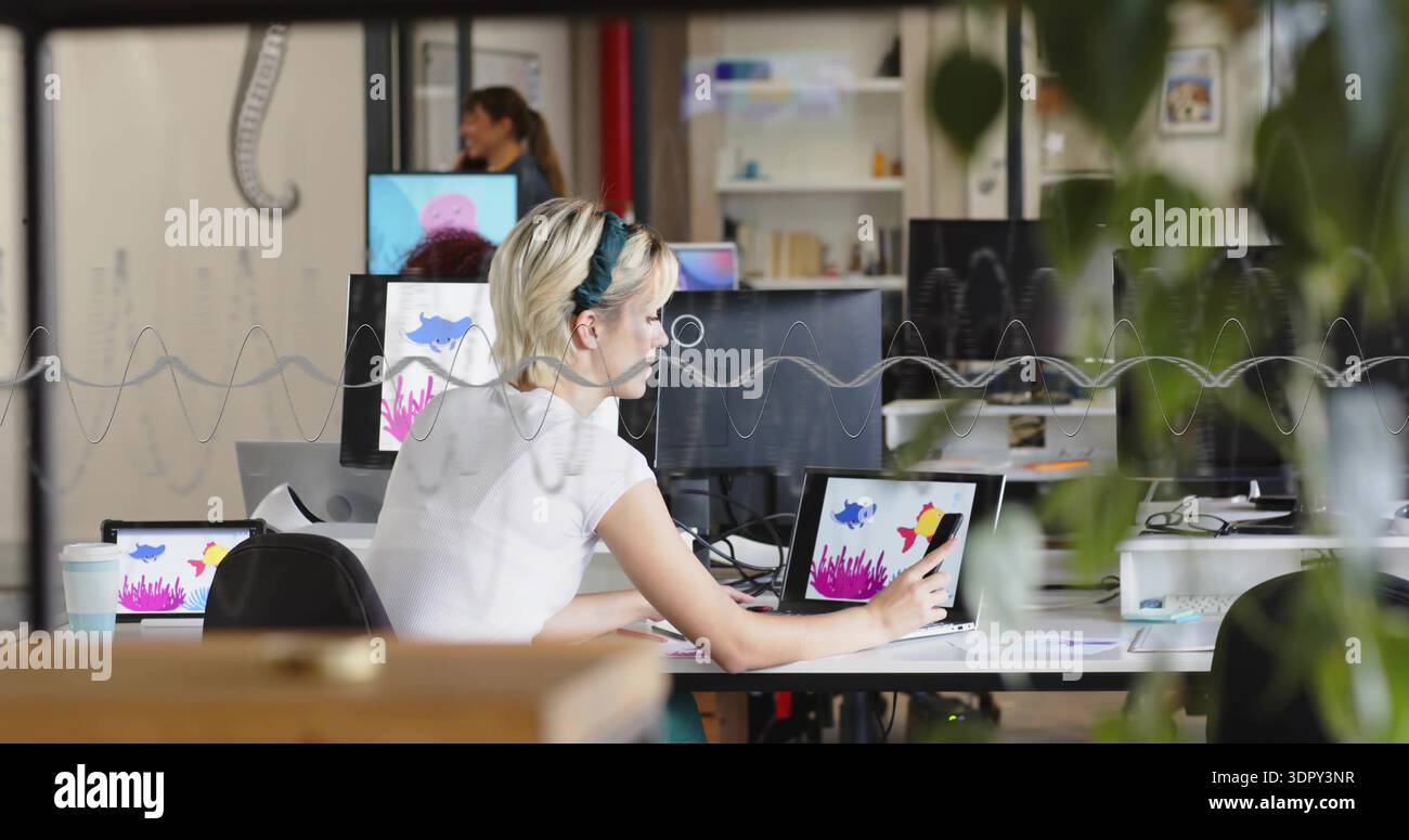 Frau in weißem Oberteil und Haarband mit Stift auf Laptop oder Tablet im Studio zeichnen, Wellenform partiti Stockfoto