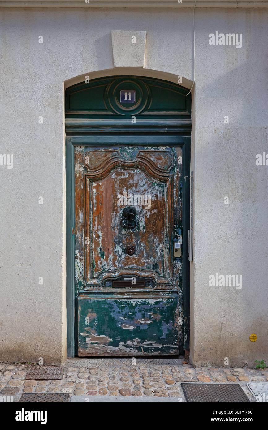Verwitterte Holztür mit abblätternder Farbe auf historischem Gebäude in der Altstadt von Avignon, Provence-Alpes-Côte d’Azur, Frankreich. Stockfoto