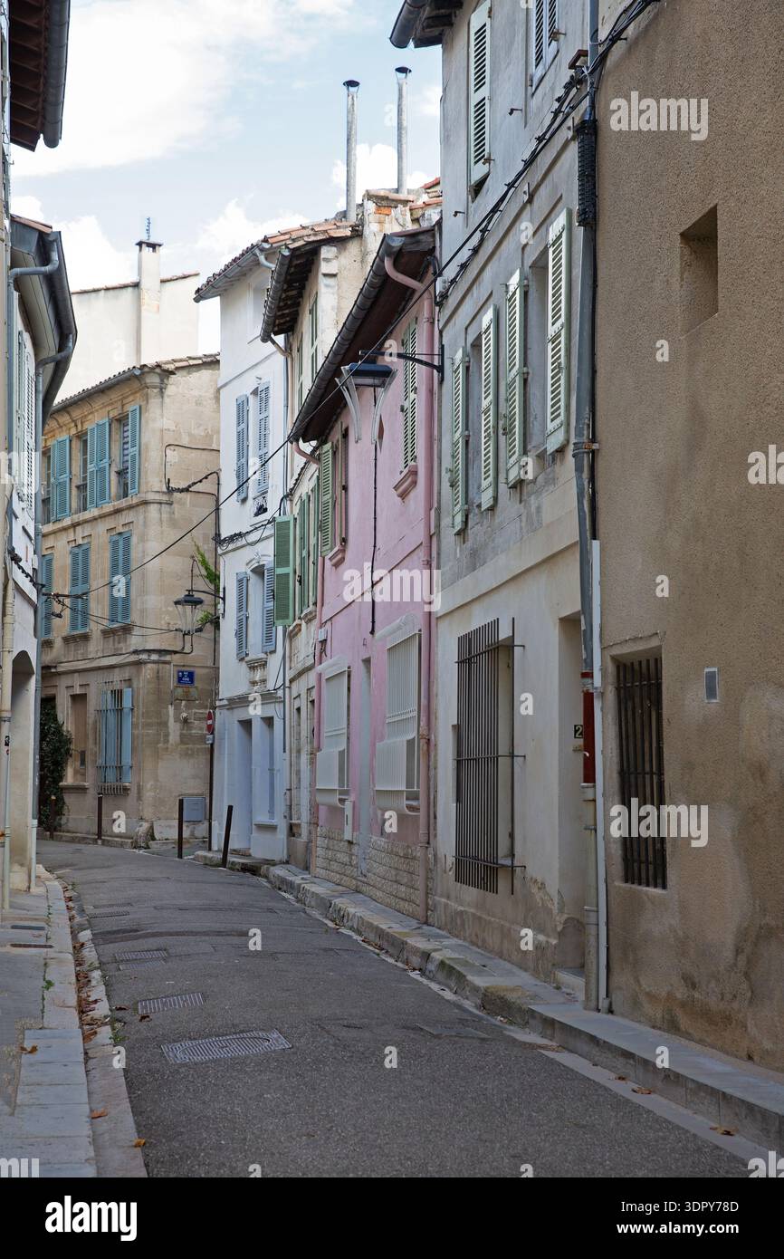 Pastellfarbene Häuser mit traditionellen Fensterläden entlang einer engen Straße in der Altstadt von Avignon, Provence-Alpes-Côte d’Azur, Frankreich. Stockfoto