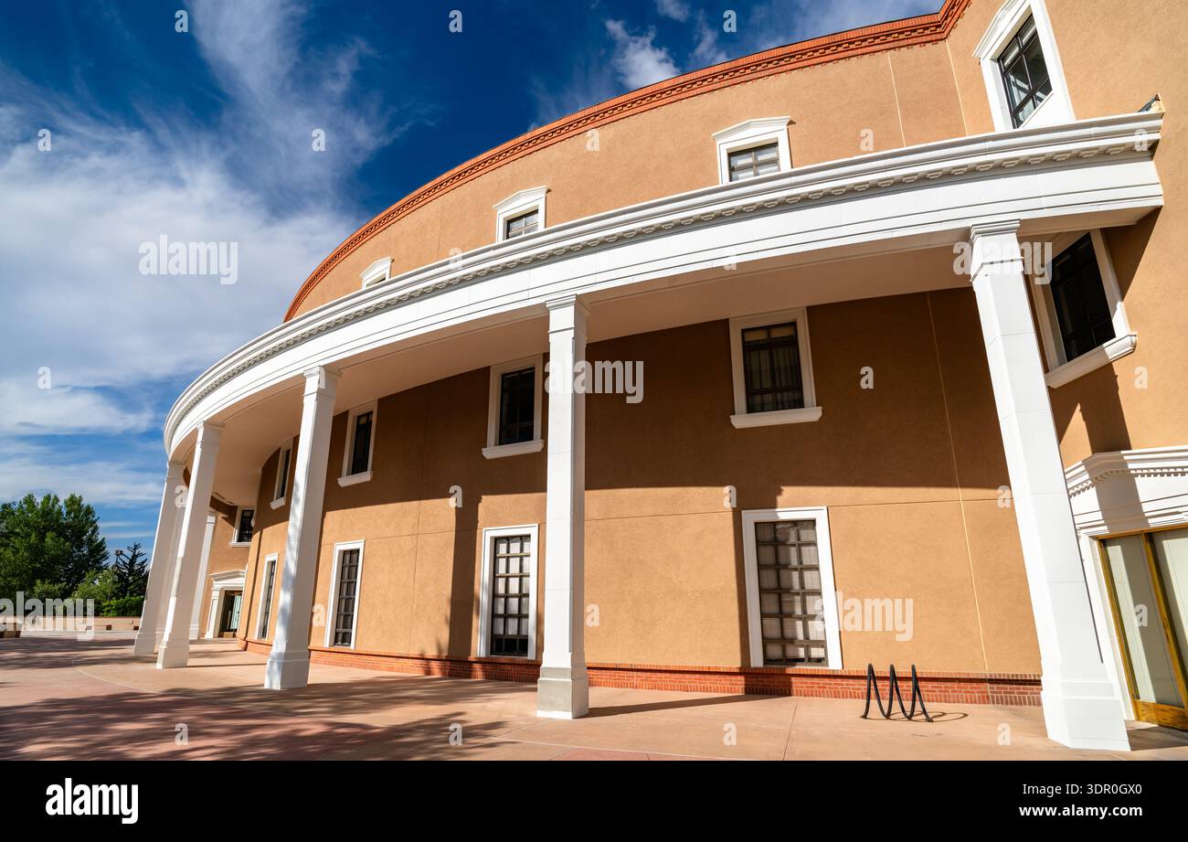 New Mexico State Capitol in Santa Fe. Die einzigartige Roundhouse-Architektur verfügt über eine geschwungene lehmfassade mit weißen Säulen und Zierleisten unter blauem Himmel Stockfoto