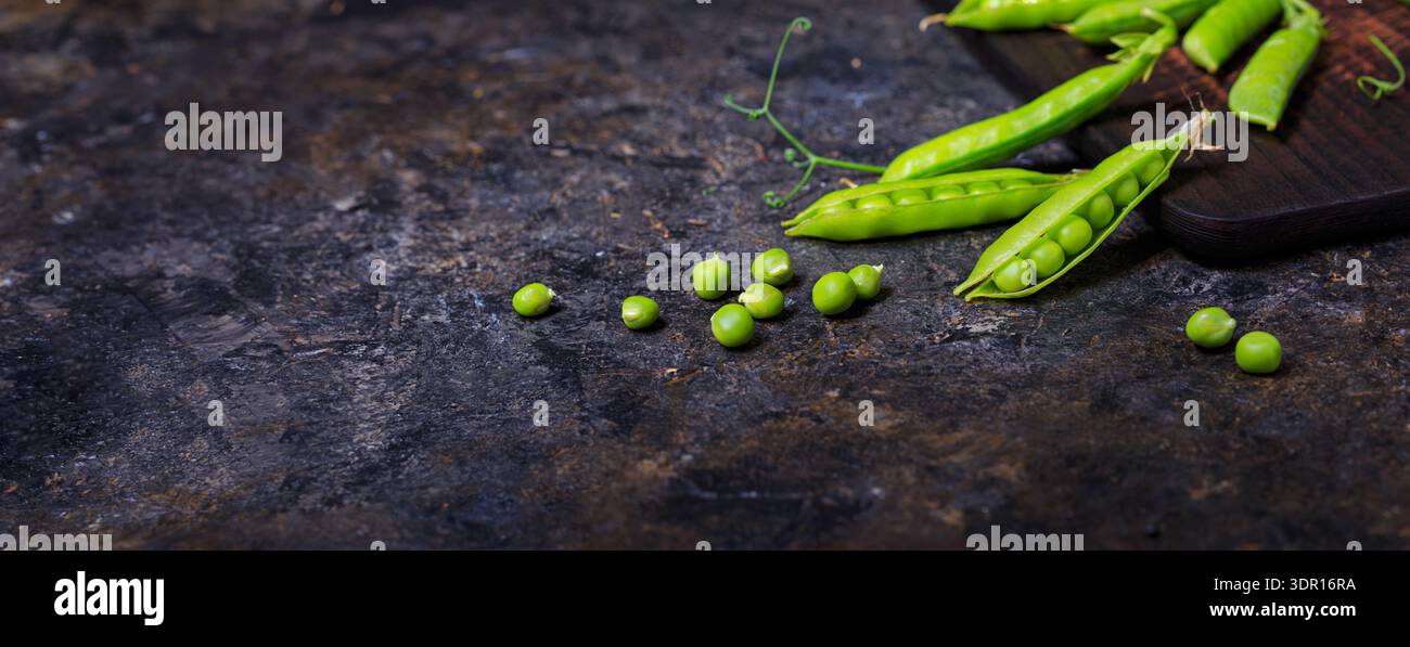 Ländliche Stillleben, Banner horizontal - Ansicht der Erbse Ernte, selektiver Fokus, Nahaufnahme auf einem dunklen Hintergrund mit Platz für Text. Das Erntekonzept Stockfoto