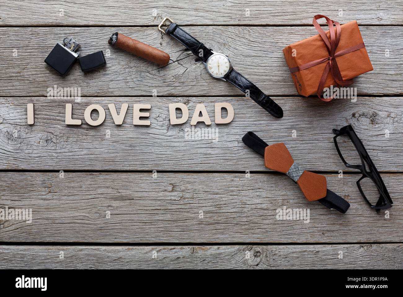 Geschenke zum Vatertag mit Uhr, Zigarre, Brille und einem Geschenk auf Holztisch Stockfoto