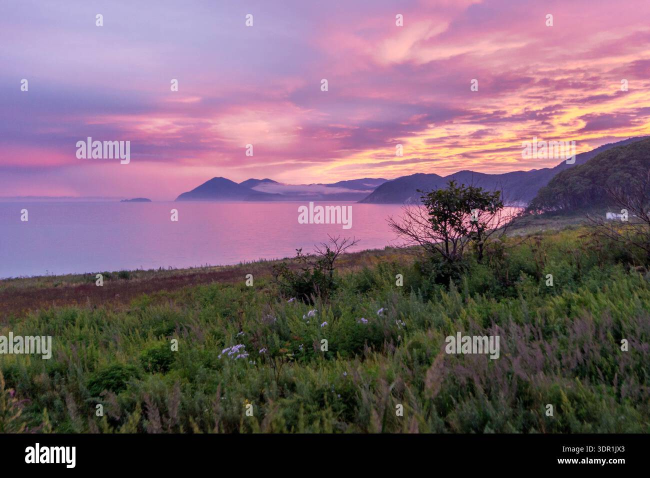 Sonnenuntergang über der Bucht von Valentin mit wunderschönem Ufer des Japanischen Meeres in Russland. Stockfoto