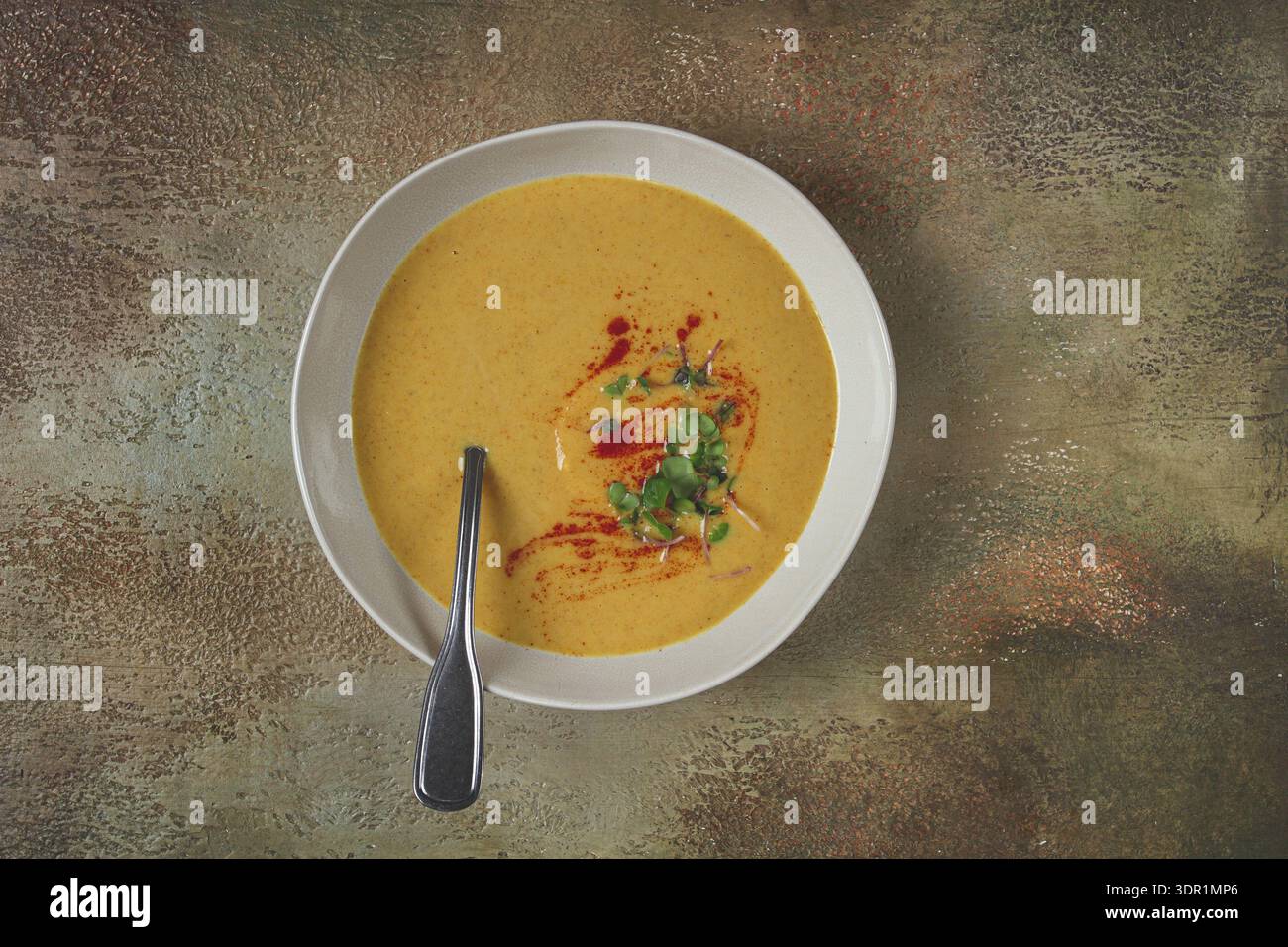 Kürbiscremesuppe, in einer weißen Schüssel auf strukturiertem Hintergrund, Blick von oben, hausgemacht, keine Leute, rustikaler Stil Stockfoto