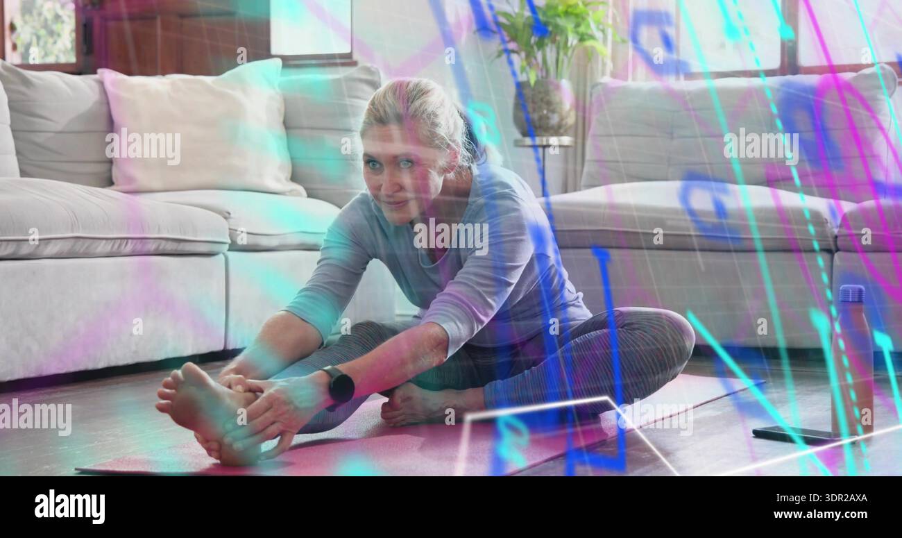 Dehnende Frau in gestreiften Leggings, die zu Hause auf Yogamatte nach Zehen greift, mit Tablette Stockfoto