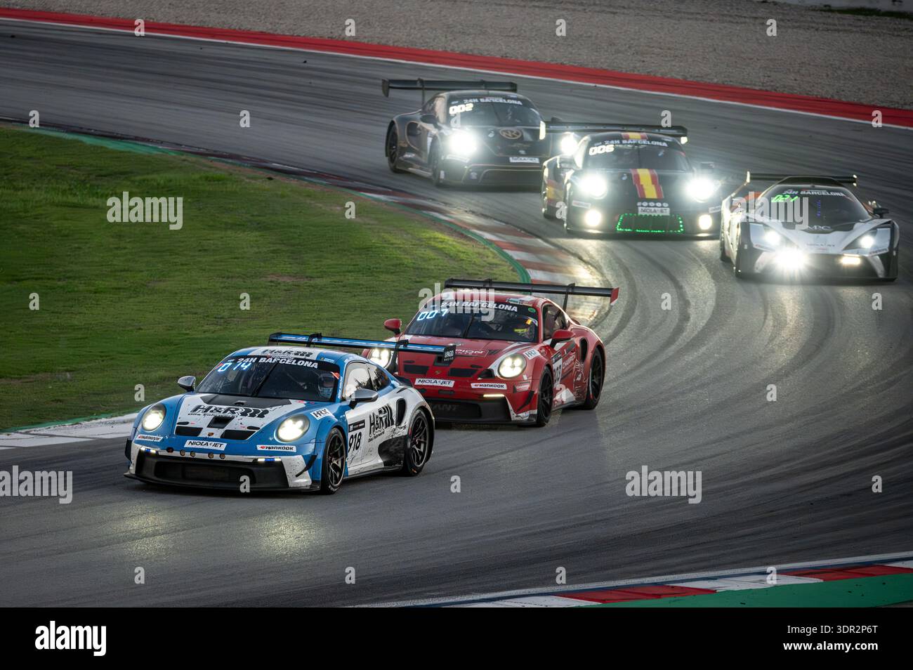 Der blau-weiße Porsche 911 GT3 Cup (992) von Muhlner Motorsport führt während der 24-Stunden-Rennen von Barcelona 2024 einen roten Porsche von Red Ant Racing an Stockfoto