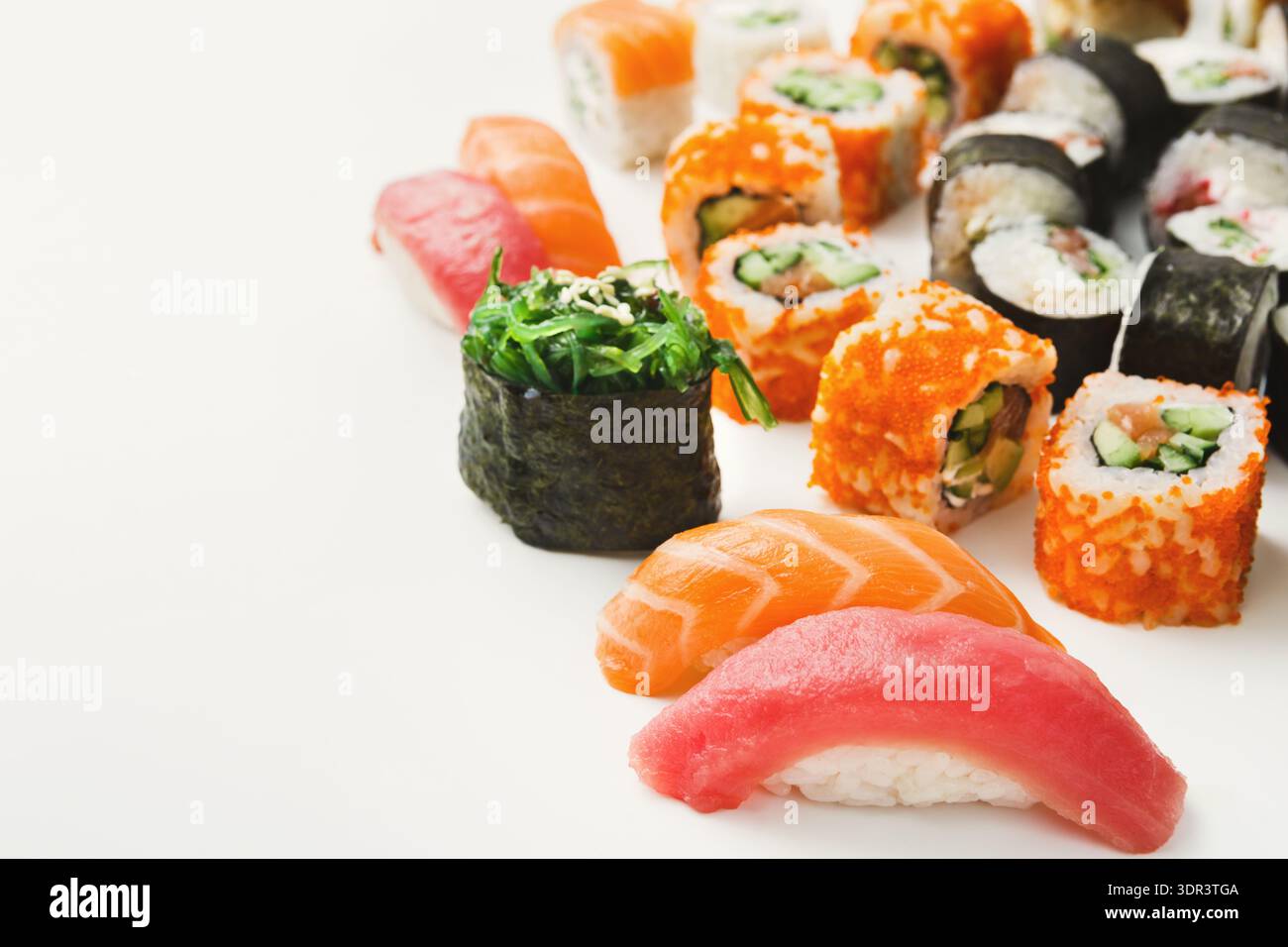 Sushi-Platte auf weißem Hintergrund mit verschiedenen Typen, einschließlich Nigiri und Rolls Stockfoto