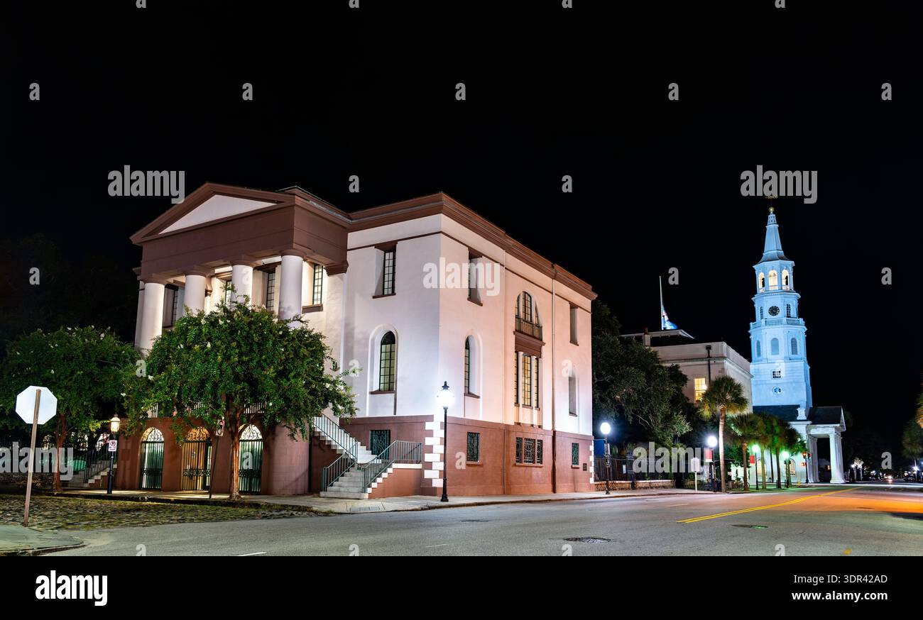 Feuerfestes Gebäude in Charleston, South Carolina. Die historische Architektur im griechischen Wiedergebrauch verfügt über einen Brownstone-Sockel und weiße Säulen in der Nähe der St. Michaels-Kirche bei Nacht Stockfoto