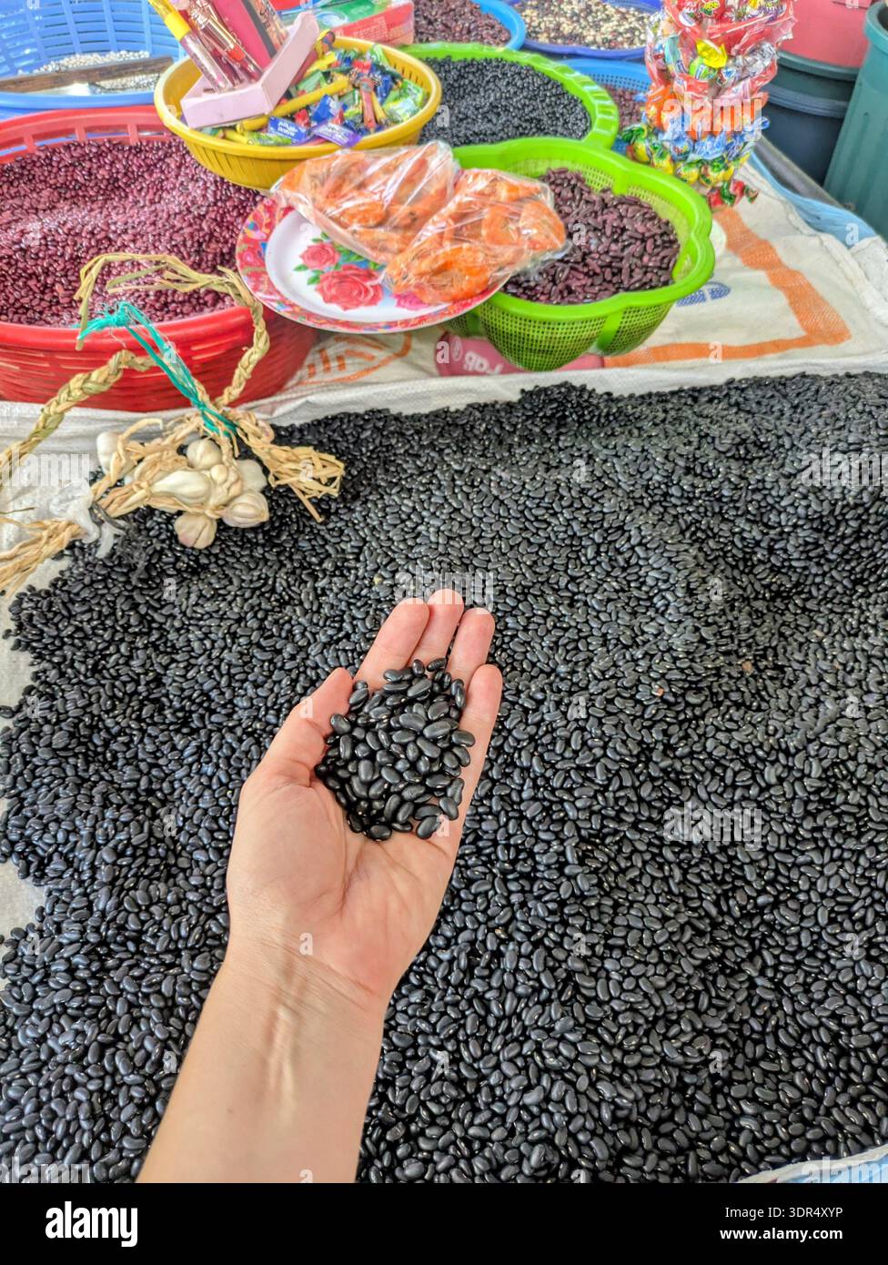 Frauen halten schwarze Bohnen am Marktstand Stockfoto