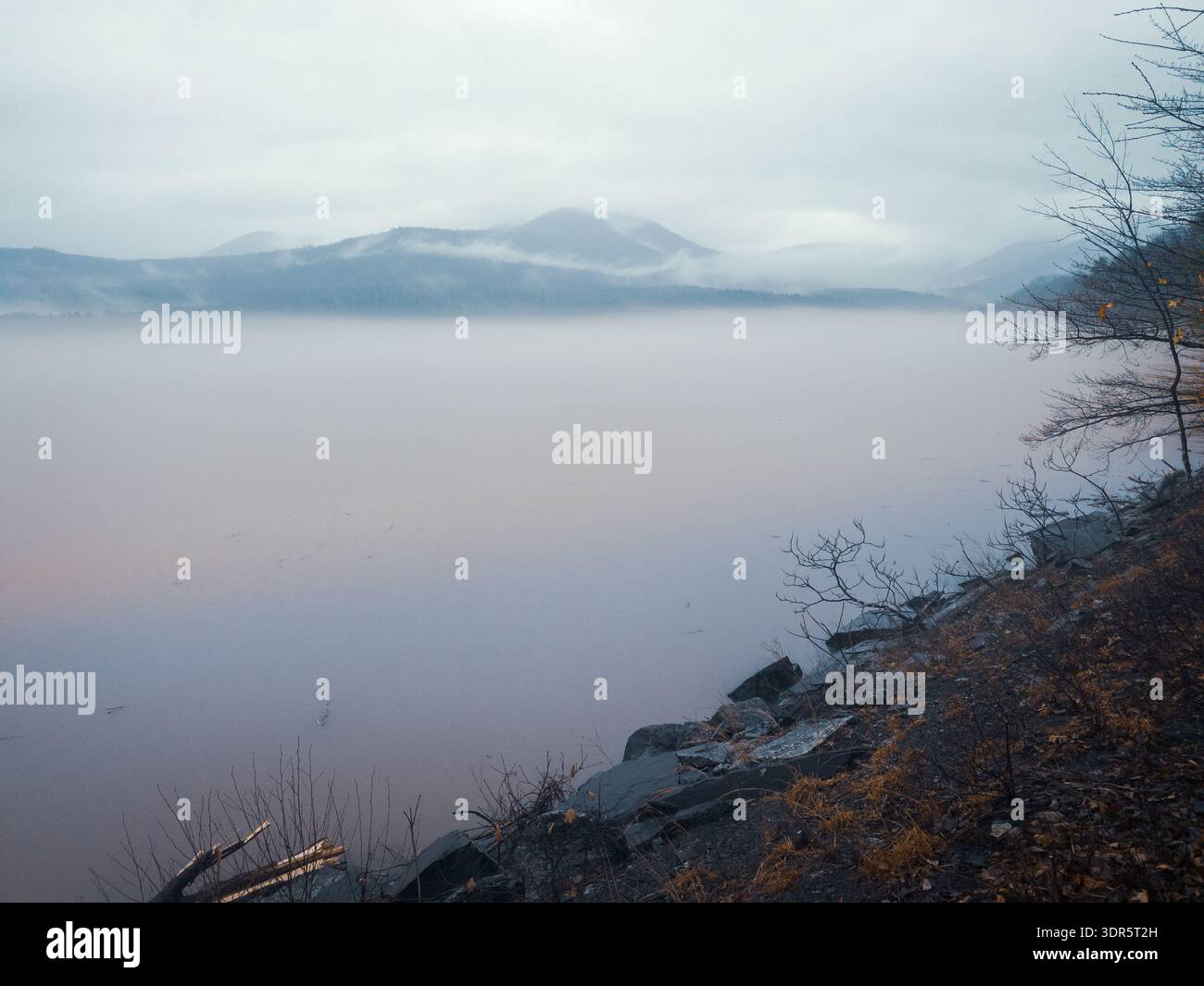 Nebel über dem Ashokan Reservoir mit den nebligen Catskill Mountains, New York, unter bedecktem Himmel. Stockfoto