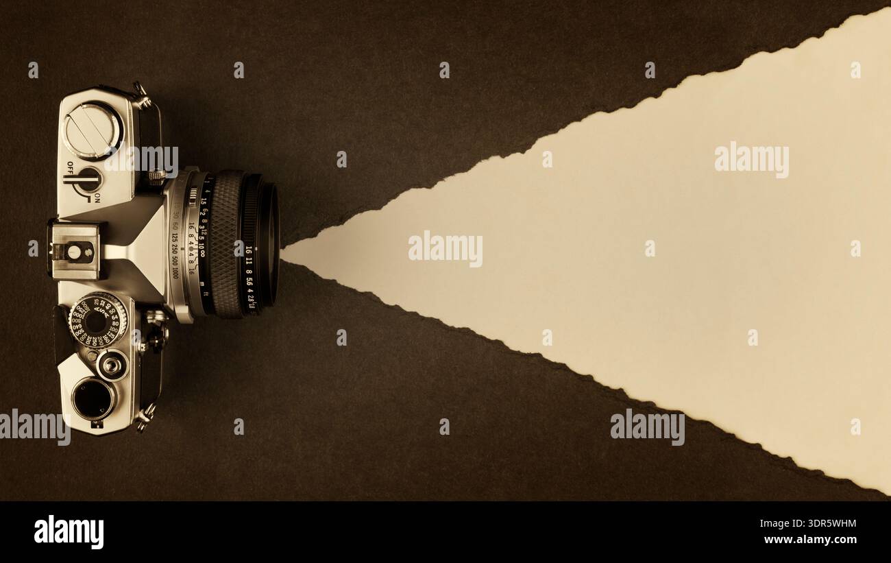 Retro-Fotokamera auf Sepia-getöntem strukturiertem Papierhintergrund mit Kopierraum Stockfoto