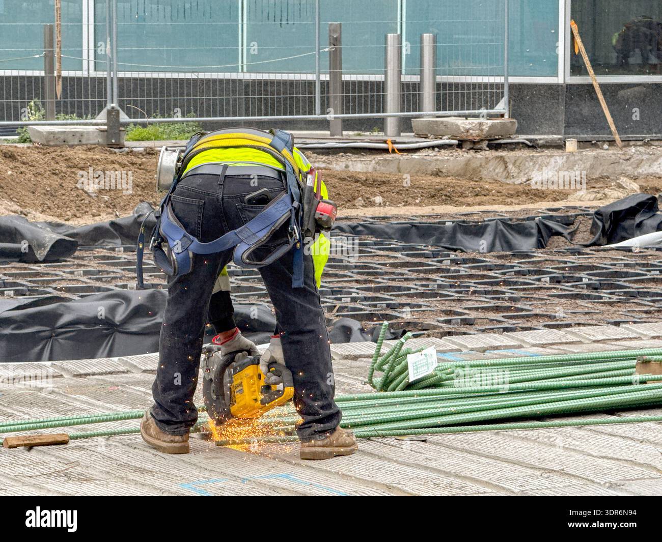 Denver, Colorado, USA - 2. Juni 2025: Bauarbeiter mit Elektrowerkzeug zum Schneiden von Stahldraht für Stahlbeton - Smartphone-aufgenommenes Stockfoto