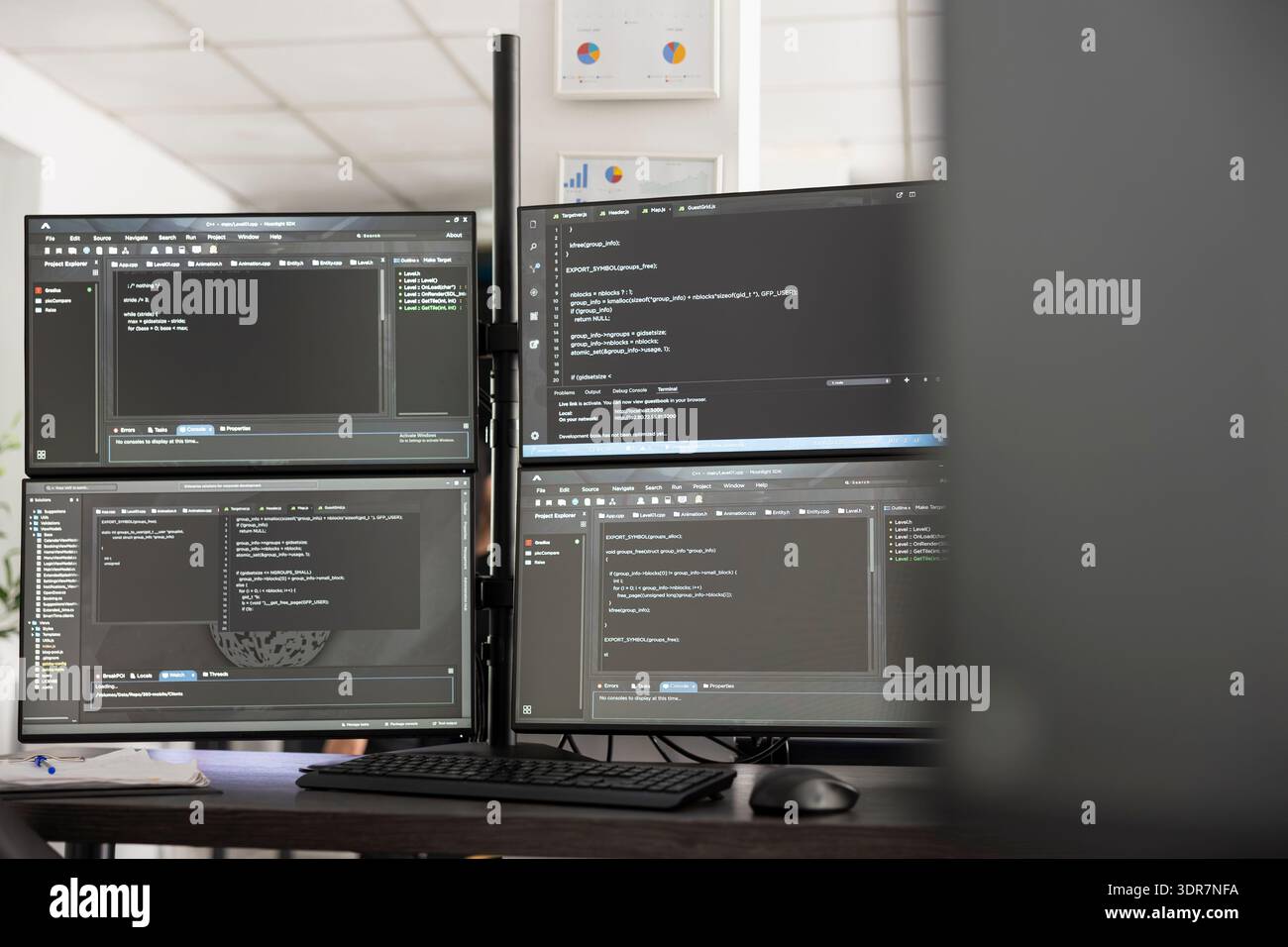 Ein leeres Startup Office zeigt mehrere Computerbildschirme mit Softwarecode und digitalen Informationen an. Clean Workspace steht für Backend-, Frontend- und Cloud-Entwicklung in modernen Workspaces. Stockfoto