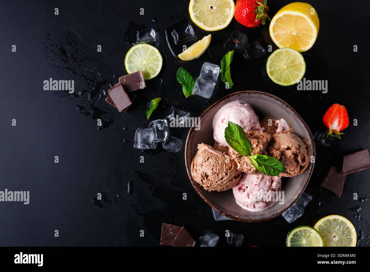 Eine Schüssel enthält verschiedene Eissorten, gepaart mit frischen Früchten wie Erdbeeren und Zitrusfrüchten Stockfoto