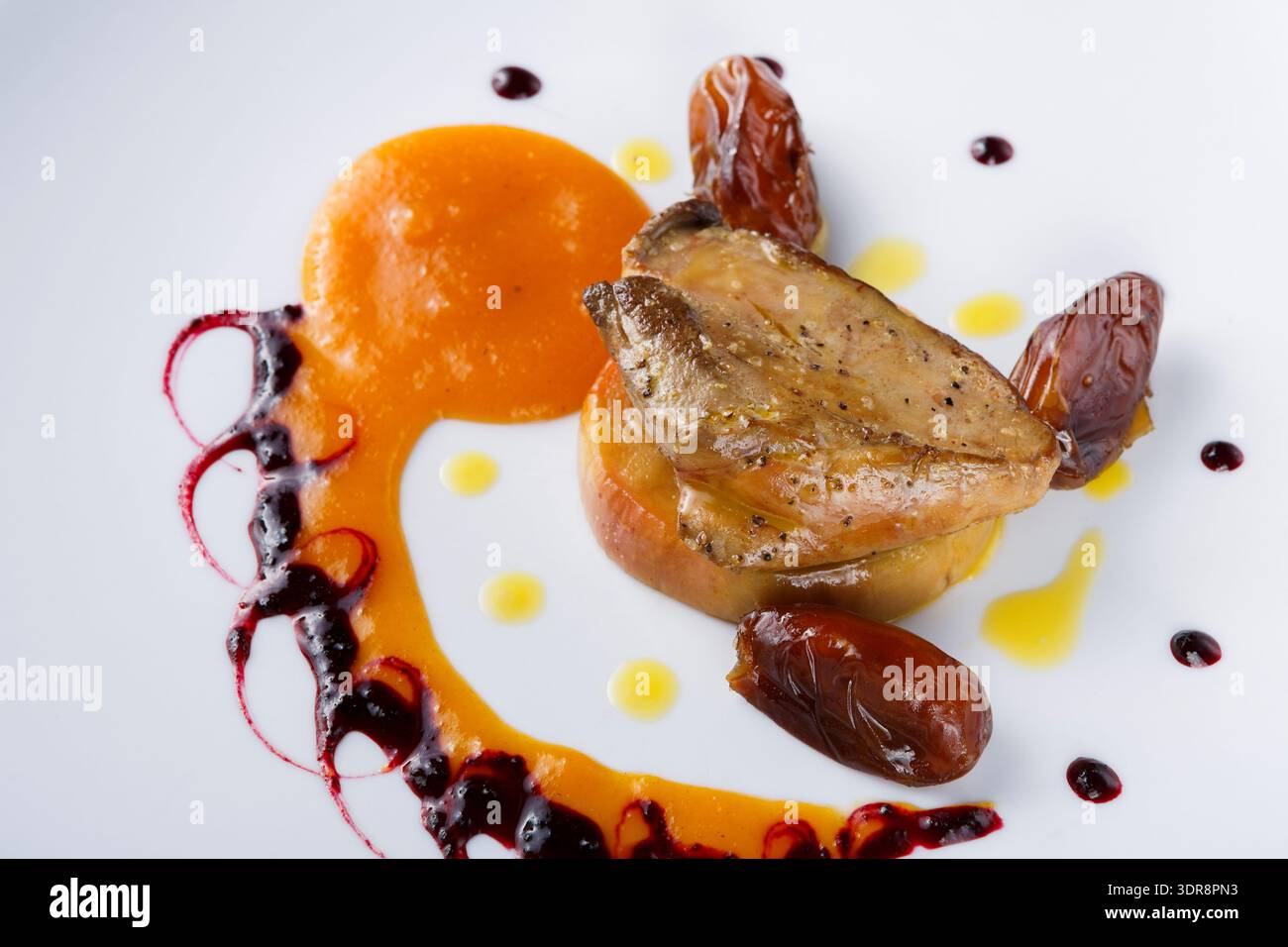 Verschiedene Arten von Lebensmittelpräsentationen auf einem weißen Teller mit farbenfroher Sauce Stockfoto