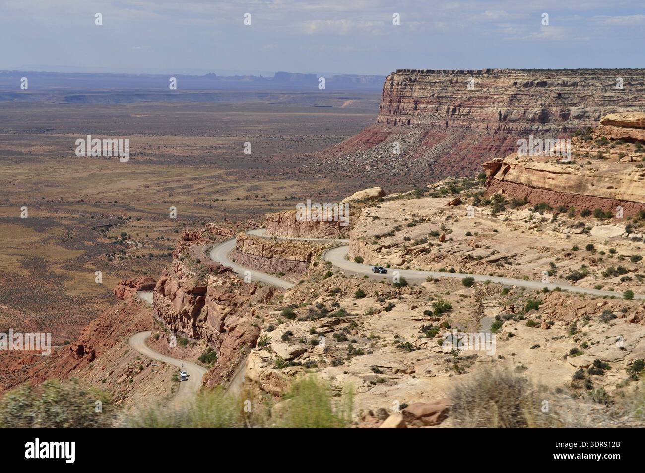 Serpentine Road schlängelt sich durch eine felsige Wüstenlandschaft mit einem atemberaubenden Ausblick, Monument Valley, Navajo Tribal Park, Navajo Nation Reservation, Utah, Ari Stockfoto