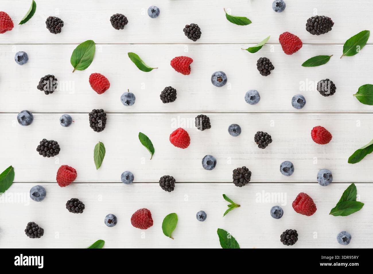 Frisches Obst und Grün auf einer Holzfläche in farbenfrohem Layout Stockfoto
