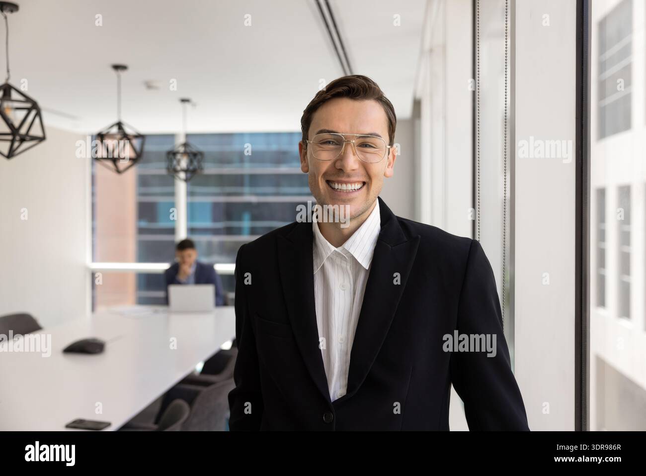 Selbstbewusster Geschäftsmann in schwarzem Anzug im modernen Tagungsraum Stockfoto