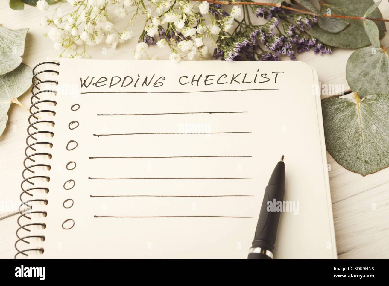 Hochzeitscheckliste für die Planung einer Veranstaltung in einem einfachen Notizbuch mit Blumen Stockfoto