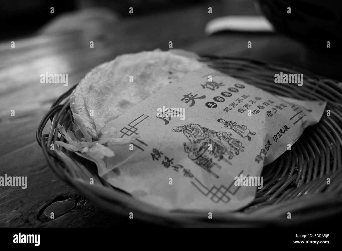 Knuspriges Fladenbrot in einem Korb in Schwarzweiß Stockfoto