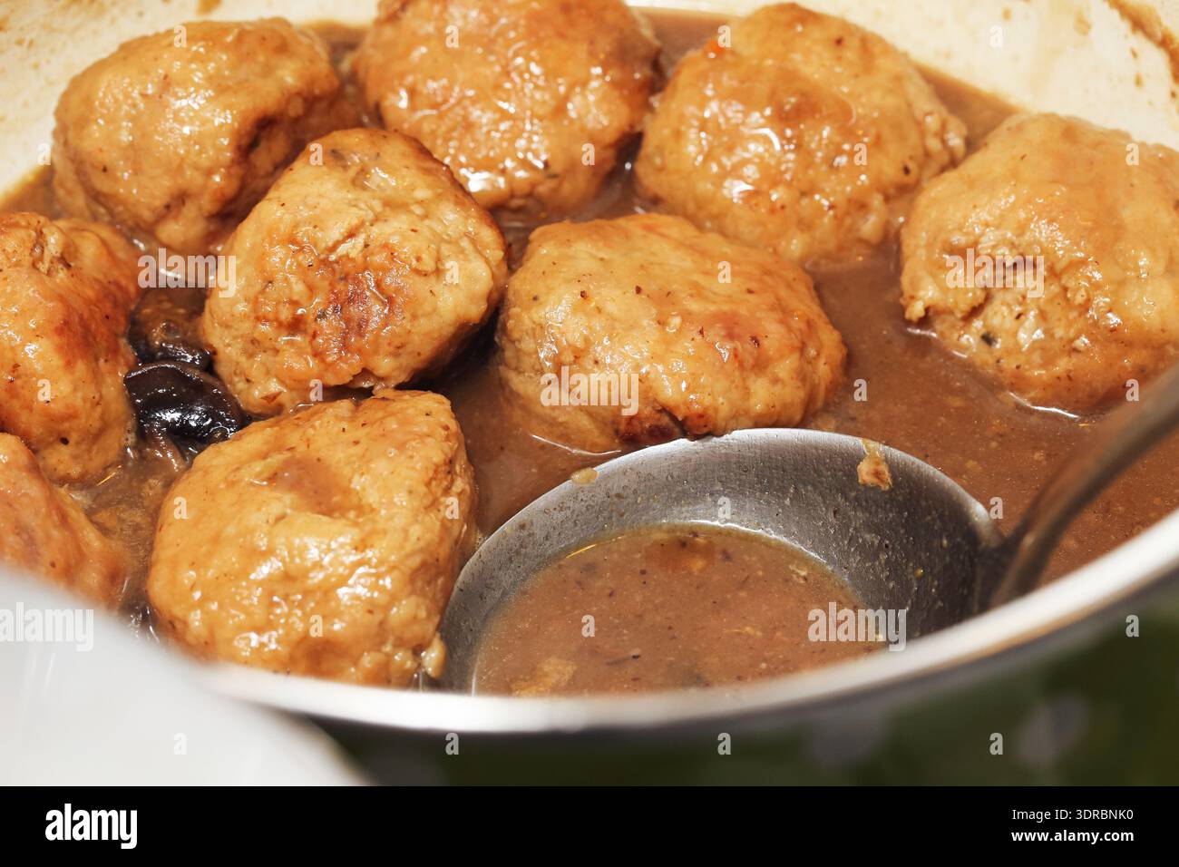 Hausgemachte Fleischbällchen, die in Soße aus der Nähe kochen. Traditionelle Komfortzubereitung und Hausmannskost in der Küche. Stockfoto